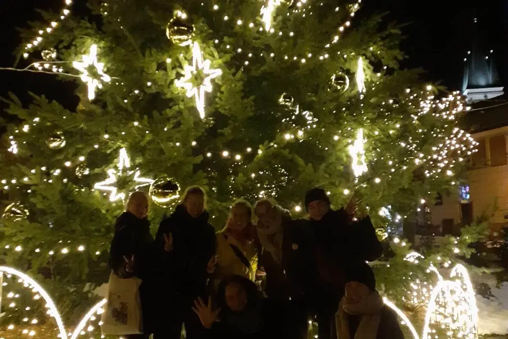 studenti před rozsvíceným vánočním stromem