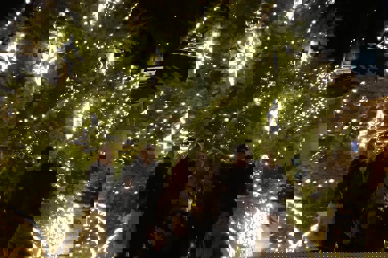 studenti před rozsvíceným vánočním stromem