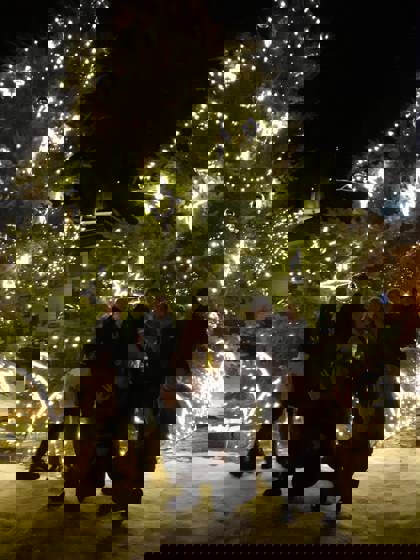 studenti před rozsvíceným vánočním stromem